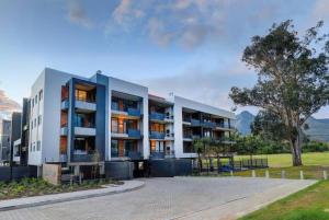 een groot wit gebouw met een boom ervoor bij 204 The Meadows in George