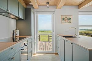 a kitchen with a sink and a view of the ocean at G421-Lemvig-Gyvelvej-21 in Lemvig