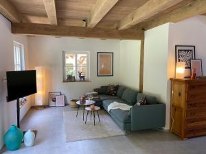 een woonkamer met een groene bank en een tv bij Ferienhaus Waldblick in Warendorf