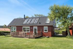 a red house with a large deck and a tree at G421-Lemvig-Gyvelvej-21 in Lemvig +16 photos
