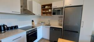 een keuken met witte kasten en een roestvrijstalen koelkast bij 204 The Meadows in George