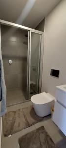 een badkamer met een douche en een wit toilet bij 204 The Meadows in George