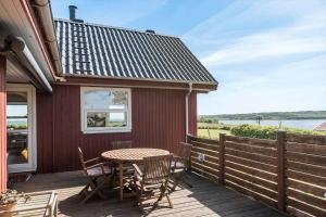 a wooden deck with a table and chairs on it at G421-Lemvig-Gyvelvej-21 in Lemvig