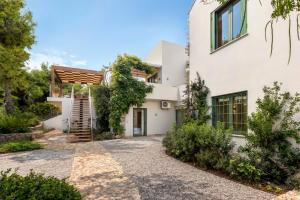 una vista exterior de una casa blanca con una escalera en Villa Levantina, en Porto Heli