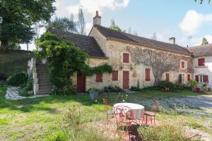 una casa con un tavolo e sedie di fronte di Lorette a Le Veurdre
