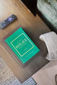 Tropical Designer King Suite - Sleeps 5 - Parking في ميسيساوغا: كتاب على طاولة بجوار ريموت كنترول