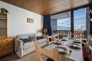 a living room with a table and a couch at Ski-in Chalet-Style View Flat - Résidence les Eterlous in Val Thorens