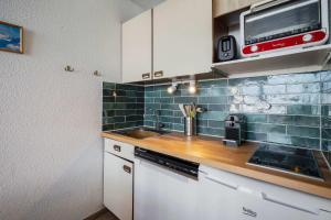 a kitchen with a sink and a microwave at Ski-in Chalet-Style View Flat - Résidence les Eterlous in Val Thorens