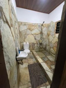 ein Steinbad mit einem WC und einem Waschbecken in der Unterkunft Sango beach in Accra