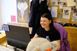a woman sitting at a desk with a laptop computer at Wild Elephants Hostel in Bratislava