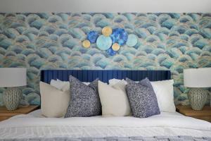 Designer 2BR - King Suite - Rare 2 Parking - YYZ في ميسيساوغا: غرفة نوم بسرير ومخدات وورق جدران