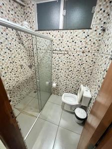 a bathroom with a toilet and a glass shower at Hotel Inter Alexandria in Cândido Mota +10 photos