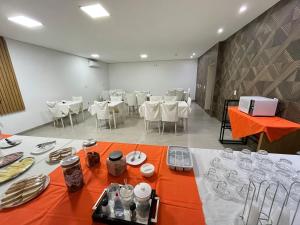 a dining room with white tables and white chairs at Hotel Inter Alexandria in Cândido Mota