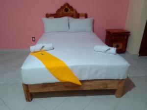 a bedroom with a large bed with a wooden headboard at Ch Aeropuerto Cuernavaca in Temixco