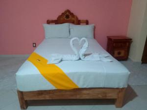 a bed with two towels in the shape of a heart at Ch Aeropuerto Cuernavaca in Temixco
