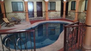 a swimming pool in a house with a balcony at Ch Aeropuerto Cuernavaca in Temixco
