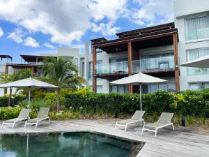 a resort with a pool and chairs and umbrellas at Ocean Point Beachfront 3-Bedroom Suites by LOV Mauritius in Pointe aux Piments