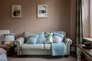 a living room with a couch with pillows on it at Burrator Inn in Yelverton +30 photos
