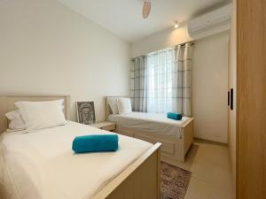 a small bedroom with two beds and a window at Ocean Point Beachfront 3-Bedroom Suites by LOV Mauritius in Pointe aux Piments +20 photos