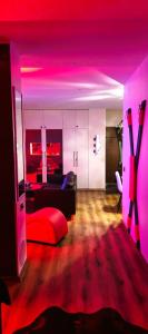 a living room with a couch and pink lighting at Red Room Luxury puhkemaja 