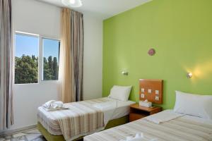 Una habitación de hotel con dos camas y una ventana. en Ilios and Irene 4, en Mastichari