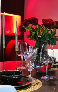 a table with wine glasses and a vase of roses at Red Room Luxury puhkemaja 