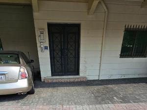 a car parked in front of a house with a door at Big & Quiet Apartment in Jurdāb