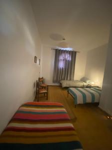 a bedroom with two beds and a rug on the floor at The Bay House Essaouira in Essaouira +18 photos