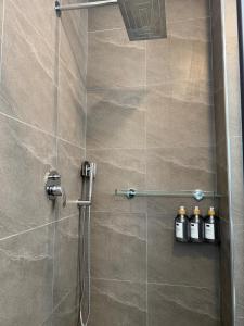 a shower stall with three bottles on a wall at Chic & Cozy Designer Space 1A in Addis Ababa +33 photos