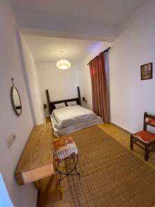 a bedroom with a bed and a table in a room at The Bay House Essaouira in Essaouira