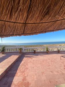 a view of the beach from a straw roof at The Bay House Essaouira in Essaouira
