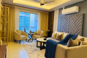 een woonkamer met een bank en stoelen bij Elysium Tower Prestige Premium Apartments Facing Centaurus Mall Islamabad in Islamabad
