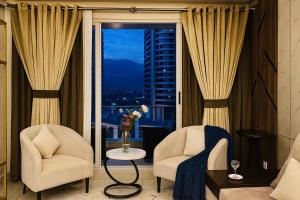 een woonkamer met 2 stoelen en een raam bij Elysium Tower Prestige Premium Apartments Facing Centaurus Mall Islamabad in Islamabad