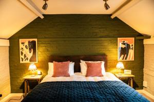 a bedroom with a large bed and two tables with lamps at The Red Lion in Thames Ditton
