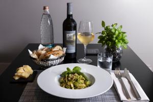 a table with a plate of food and a glass of wine at Holiday Inn Genoa City by IHG in Genoa +47 photos