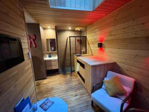 ein Raum mit einer Bank und einem Waschbecken in einem Raum in der Unterkunft Au Plaisir Vosgien in Raon-lʼÉtape