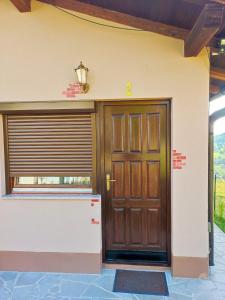 a house with a wooden door and a window at Domus Foresta Apartmani in Brdo