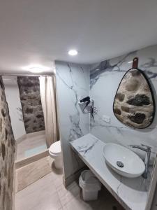 a bathroom with a white sink and a toilet at Kay Pacha Wellness Place Eco in Ayacucho