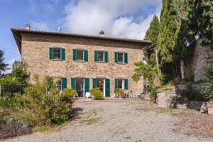 an old stone house with green shutters and a yard at Dimora Vecchio Duomo - Together in Tuscany in Cortona