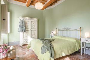 a bedroom with a bed in a room with green walls at Dimora Vecchio Duomo - Together in Tuscany in Cortona