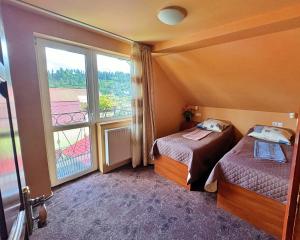 a hotel room with two beds and a large window at U Nazara in Slavske +58 photos