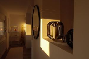 een gang met een spiegel en wat vazen op een plank bij Konstanz Lakeside Apartment in Reichenau