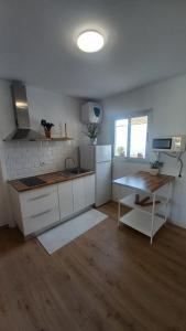 eine Küche mit weißen Schränken und einem Tisch darin in der Unterkunft Villa Star in Agaete