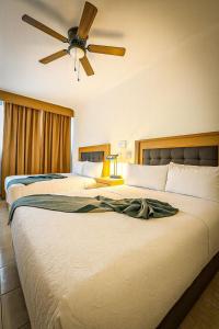 2 camas en una habitación de hotel con ventilador de techo en Hotel Grand Lion, en Torreón
