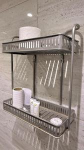 a metal shelf with cups and towels on it at Bright Star Hotel in AlUla