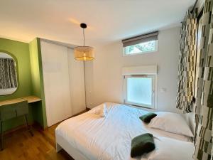 Le Jupiter, Centre ville, Parking Privé في بورجوا: غرفة نوم بسرير أبيض ونافذة