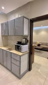 a kitchen with a microwave on top of a counter at Bright Star Hotel in AlUla