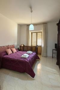 una camera con letto viola e finestra di Domus Poppea - a 5 minuti da Pompei e parcheggio gratuito a Torre Annunziata