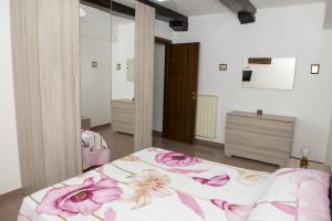 a bedroom with a bed with pink flowers on it at Casa Piazza Garibaldi in Sulmona