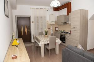 a kitchen and dining room with a table and a couch at Casa Piazza Garibaldi in Sulmona